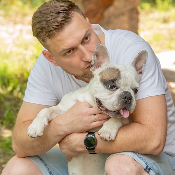 Man Sitting With Frenchie Outside